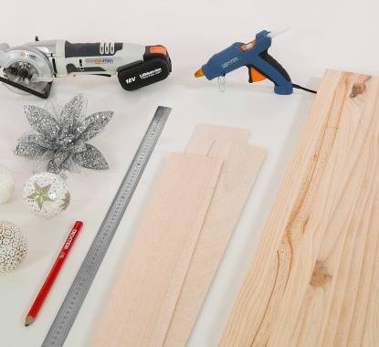 ripas de madeira, pistola de cola, régua, lápis, decorações de Natal